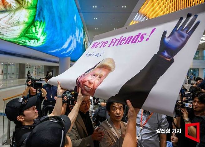 미국 조지아주 이민세관단속국(ICE) 구금 시설에서 체포·구금됐다 풀려난 한국인 316명이 탑승한 전세기가 지난해 9월 인천국제공항 2터미널에 도착한 가운데, 이제석 이제석광고연구소 대표가 입국장에서 트럼프 대통령을 비판하는 선전문을 들어 보였다. 강진형 기자