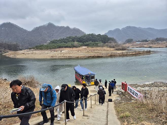 Visitors get off a boat and walk towards Cheongnyeongpo, a scenic spot in Yeongwol County, Gangwon, on March 6. [PARK JIN-HO]