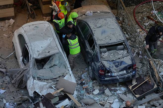 11일(현지시간) 레바논 베이루트의 아파트에서 이스라엘 공습으로 피해를 입은 현장에서 구조대원들이 한 남성을 돕고 있다. [AP]