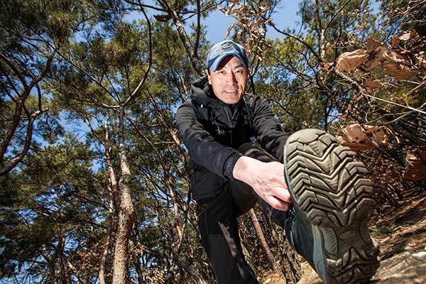 등산화 끈을 묶고 있는 이상만씨.