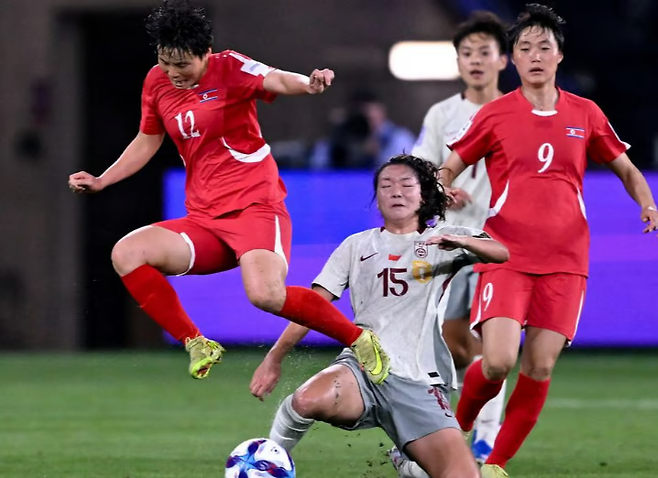 북한 여자 축구 대표팀 선수들(빨간 유니폼)이 10일 중국과의 2026 아시안컵 조별리그 B조 3차전 중국과 경기에서 볼을 다투고 있다. 신화연합뉴스