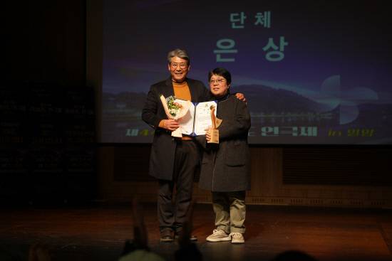 지난 11일 밀양아리랑아트센터에서 열린 제44회 경남연극제 시상식에서 '웃으면 장수하리'로 단체 은상을 받은 김은민(오른쪽) 극단 메들리 연출이 수상 기념 사진을 찍고 있다. 백지영기자