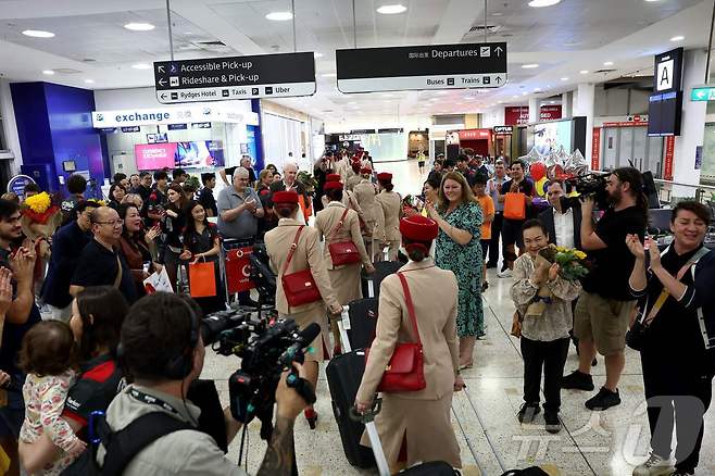 지난 4일, 두바이발 항공편으로 시드니 킹스포드 스미스 국제공항에 도착한 에미레이트항공 승무원들을 승객들의 가족과 친구들이 환호하며 맞이하고 있다.ⓒ AFP=뉴스1
