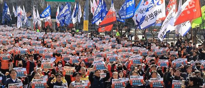 '노란봉투법'(노동조합 및 노동관계조정법 2·3조 개정 법률) 시행 첫날인 지난 10일 서울 세종로에서 열린 민주노총 투쟁 선포대회에서 민주노총 조합원들이 손팻말을 들고 구호를 외치고 있다. 연합뉴스 제공