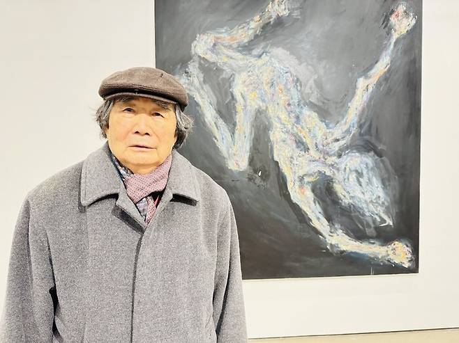 권 화가가 나치의 유대인 학살을 떠올리며 그린 전시작 앞에서 사진을 찍고 있다. 강성만 선임기자