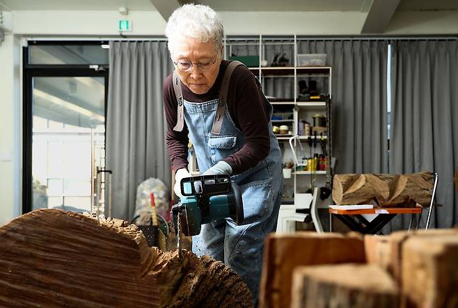 지난달 19일 경기도 파주 작업실에서 만난 조각가 김윤신. 전기톱으로 나무를 자르고 있다. 파주=우상조 기자
