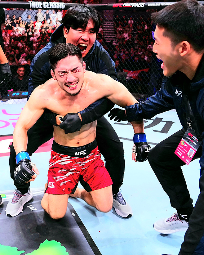 Road to UFC 시즌3 밴텀급 토너먼트 우승자 유수영이 2025년 8월 중국 상하이다우타이에서 UFC 정규 파이터로 데뷔 2연승을 달성한 후 기뻐하고 있다. 뒤는 블랙컴뱃 오피셜짐 최효준 관장. 사진=TKO