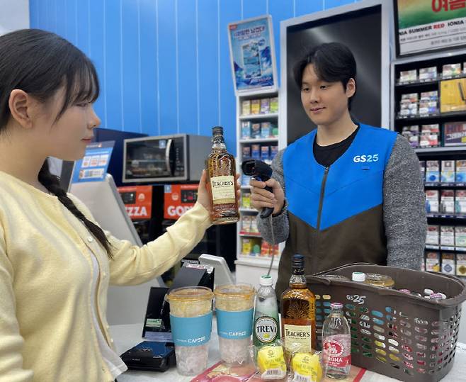 GS25에서 모델이 가성비 위스키 티처스와 하이볼 관련 상품을 구매하고 있다. (사진=GS리테일)