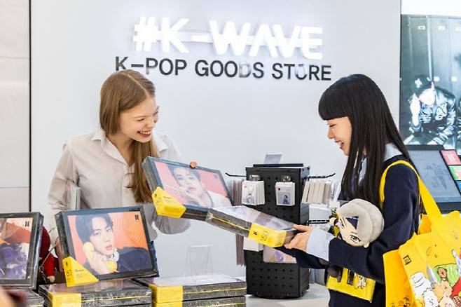 신세계면세점이 그룹 방탄소년단 광화문 공연을 앞두고 K컬처 콘텐츠와 쇼핑 혜택을 강화한다고 11일 밝혔다. 사진은 외국인 모델들이 신세계면세점 명동점 'K-웨이브 존'에서 BTS 굿즈를 살펴보는 모습.(사진=신세계면세점)