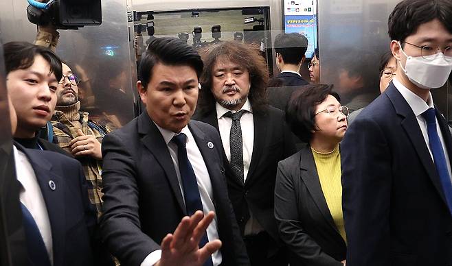 방송인 김어준씨가 2024년 12월 13일 국회 과학기술정보방송통신위원회 전체회의에서 계엄 당시 암살조 가동 등 제보 내용을 밝힌 뒤 국회 경위들의 보호를 받으며 떠나고 있다. 2024.12.13 [사진=연합뉴스]