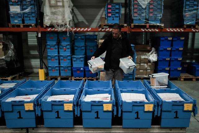 12일 프랑스 브뤼주 시립 창고에서 시청 공무원이 지방선거 유권자 등록 카드가 든 소박스를 각 투표소로 보낼 파란색 대형 박스에 담고 있다.  AFP 연합뉴스