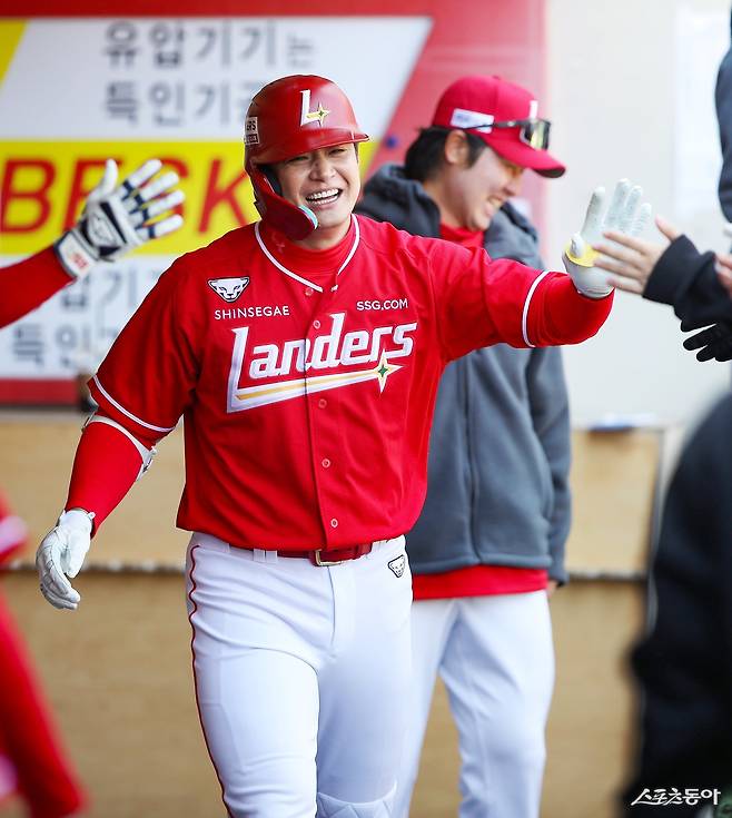 SSG 김재환이 13일 광주-기아챔피언스필드서 벌어진 KIA와 시범경기 2회초 첫 홈런을 뽑아낸 뒤 동료들과 하이파이브를 하고 있다. 사진제공ㅣSSG 랜더스