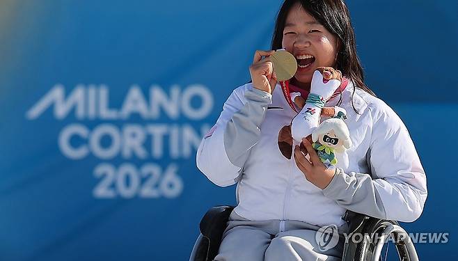 '스마일리' 김윤지, 금맛꿀맛 (테세로=연합뉴스) 한종찬 기자 = 8일(현지시간) 이탈리아 테세로 크로스컨트리 스타디움에서 열린  2026 밀라노·코르티나 동계패럴림픽  파라바이애슬론 여자 스프린트 좌식 12.5㎞ 시상식에서 한국 김윤지가 금메달을 목에 걸고 기뻐하고 있다. 2026.3.8 saba@yna.co.kr