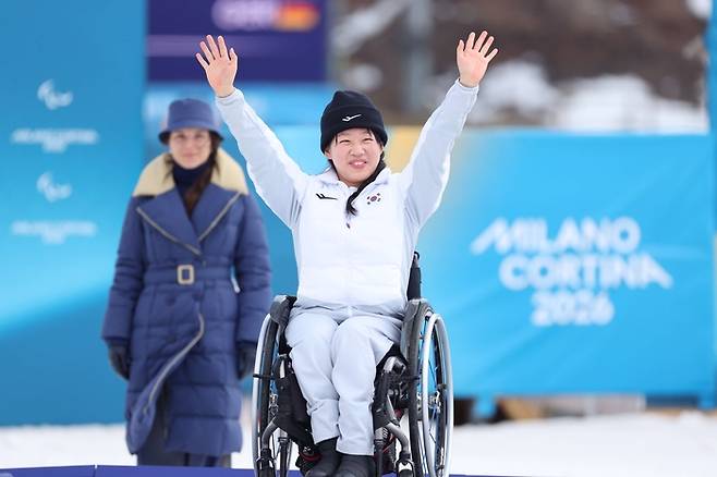 김윤지가 13일(현지시간) 이탈리아 테세로 크로스컨트리 스타디움에서 열린 2026 밀라노·코르티나 동계패럴림픽 여자 바이애슬론 스프린트 추적 좌식 은메달을 따낸 후 시상대에 올라 환호하고 있다. 사진 | 대한장애인체육회