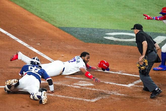 한국 대표팀 포수 박동원(왼쪽)이 14일 미국 플로리다주 마이애미 론디포파크에서 열린 WBC 8강전에서 홈으로 쇄도하는 도미니카공화국 블라디미르 게레로 주니어를 태그하기 위해 몸을 던지고 있다. 결과는 세이프. 사진 | AFP 연합뉴스