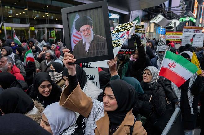 미국 뉴욕에서 13일(현지시간) 이란인들이 사망한 아야톨라 알리 하메네이의 사진과 이란 국기를 들고 집회를 벌이는 모습./AFP연합뉴스,게티이미지