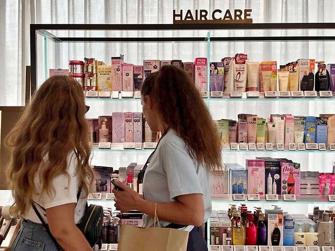 Customers browse hair care products at an Olive Young store in Seoul. (CJ Olive Young)