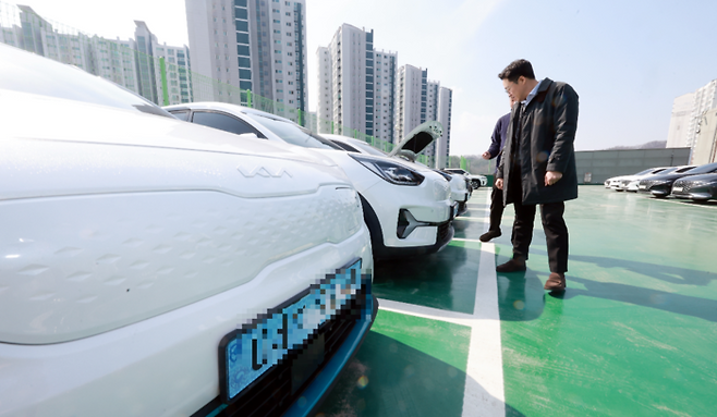 지난 10일 경기도 용인시 기흥구에 있는 롯데렌탈 티카 용인 중고차 매매단지에서 중고차를 보러 온 소비자들이 전기차를 살펴보고 있다. [김재훈 기자]