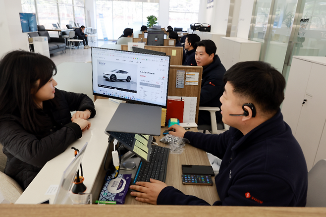 지난 10일 경기도 용인시 기흥구에 있는 롯데렌탈 티카 용인 중고차 매매단지에서 중고차를 보러 온 소비자들이 전기차를 살펴보고 있다. [김재훈 기자]