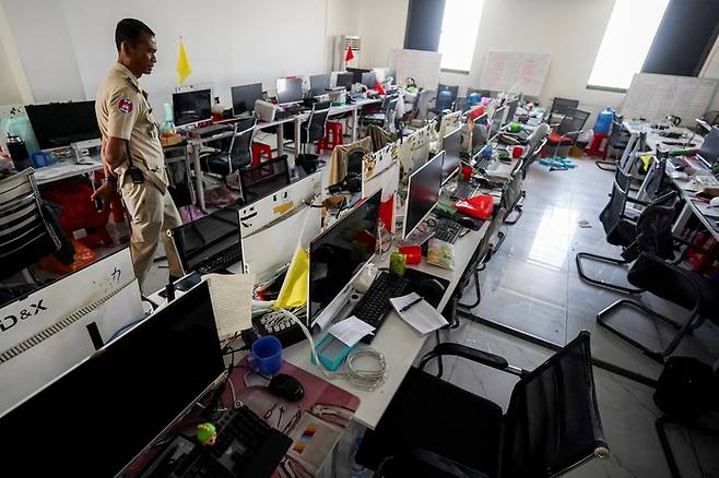 캄보디아 경찰이 온라인 피싱 범죄 조직의 ‘사기 공장’을 수색하는 모습 [사진 출처 = 로이터 연합뉴스]