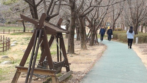 지난 14일 운천저수지 수변공원에서 시민들이 산책로를 거니는 모습. 김현수 기자