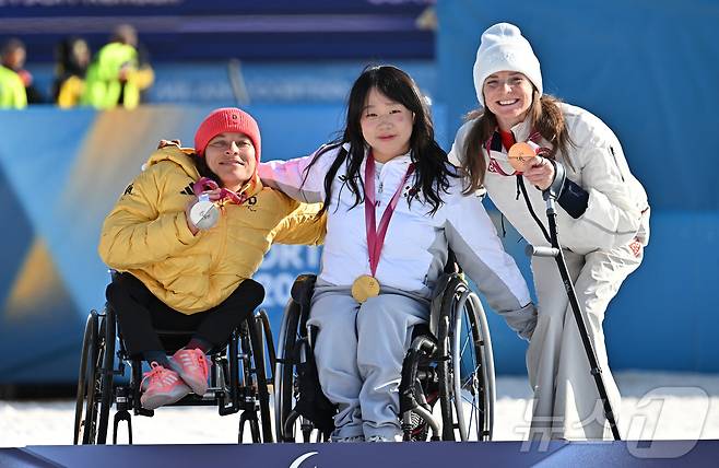 바이애슬론 김윤지가 8일(현지시간) 이탈리아 테세로 크로스컨트리 스키 스타디움에서 열린 2026 밀라노 코르티나 동계패럴림픽 바이애슬론 12.5km 시상식에서 금메달을 목에 건 후 은메달을 차지한 독일 비커 안야(왼쪽), 동메달을 차지한 그레치 켄달(미국)과 함께 기념촬영을 하고 있다. 2026.3.9 ⓒ 뉴스1 사진공동취재단