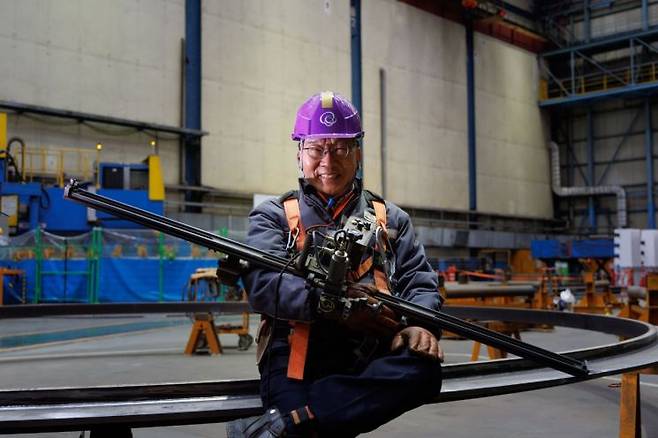 박순복 한화오션 명장이 11일 거제 옥포조선소에서 본인이 개발한 '위빙 캐리지' 장비를 들어 보이고 있다. 이 장비는 용접기가 일정한 속도로 이동하면 좌우로 흔들리듯 움직여 자동 용접을 돕는다. 한화오션