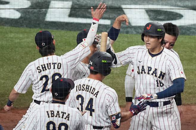 <yonhap photo-3021="">오타니 쇼헤이가 15일(한국시간) 열린 베네수엘라와 WBC 8강전 1회 말 동점 솔로 홈런을 터뜨린 뒤 동료들의 축하를 받고 있다. AP=연합뉴스</yonhap>