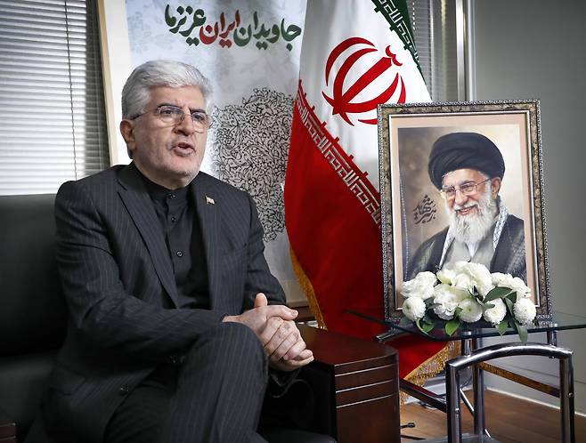 Iranian Ambassador to South Korea Saeed Koozechi speaks during an exclusive interview with the Korea JoongAng Daily at the Iranian Embassy in central Seoul on March 13. Behind him hangs a portrait of the late Supreme Leader Ali Khamenei, alongside a map of Iran inscribed with the words "Eternal Iran" in Persian — a backdrop arranged at the ambassador's request. [PARK SANG-MOON]