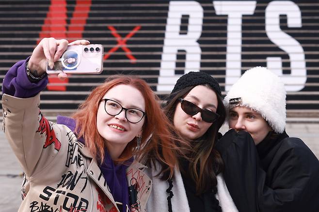 서울 종로구 세종문화회관 계단에서 러시아 관광객들이 방탄소년단(BTS) 공연 홍보물을 배경으로 기념촬영을 하고 있다. 연합뉴스