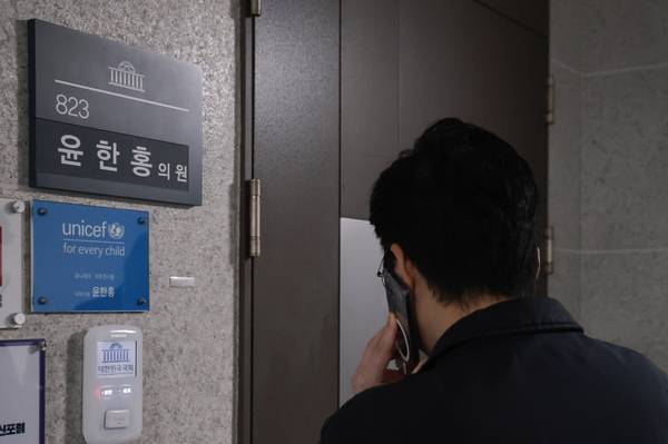 2차 종합특검팀이 '관저 이전 의혹'과 관련해 국민의힘 윤한홍 의원에 대한 압수수색에 나선 16일 국회 의원회관 내 윤 의원 사무실 앞에서 의원실 관계자가 통화하고 있다. /연합뉴스