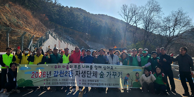 한국남부발전 부산빛드림본부 임직원들이 지난 13일, 발전소 인근 주민들과 함께 ‘자생단체 숲 가꾸기 식목행사’를 마친 후 기념 촬영을 하고 있다.(사진제공=한국남부발전)