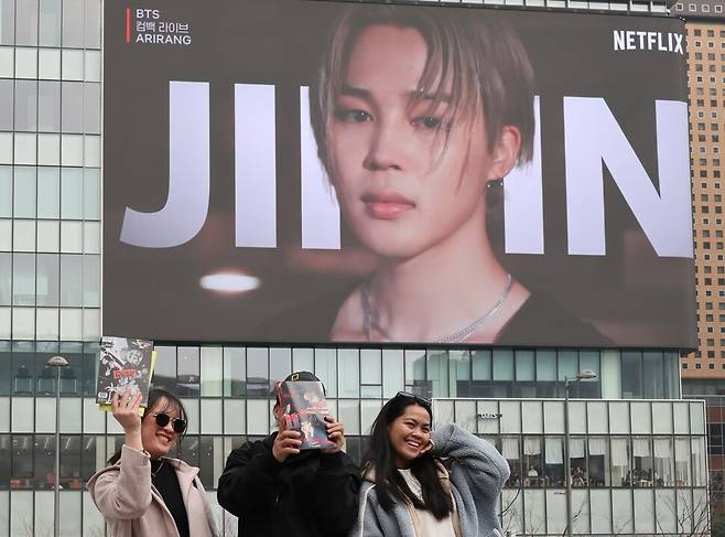 서울 종로구 광화문 일대에서 열리는 방탄소년단(BTS) 컴백 공연을 6일 앞둔 15일 오후 서울 종로구 광화문 광장에서 빌딩 전광판에 나오는 공연 홍보 영상을 배경으로 콘서트를 보러 온 필리핀 관광객들이 기념 영상을 찍고 있다. 김혜윤 기자 unique@hani.co.kr