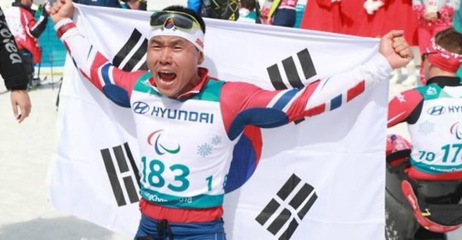 대한민국 신의현이 17일 오후 강원도 평창 바이애슬론센터에서 열린 2018 평창동계패럴림픽 크로스컨트리스키 남자 7.5㎞ 좌식 경기에서 금메달을 차지한 뒤 태극기를 들고 포효하고 있다. IS 포토