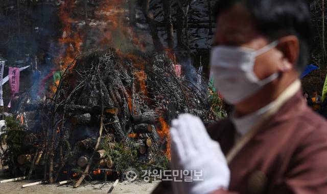 ▲ 16일 평창 월정사에서 봉행된 선덕 자광당 원행 대종사 다비식에서 한 신도가 기도를 하며 붉게 타오르는 연화대를 돌고 있다. 방도겸 기자