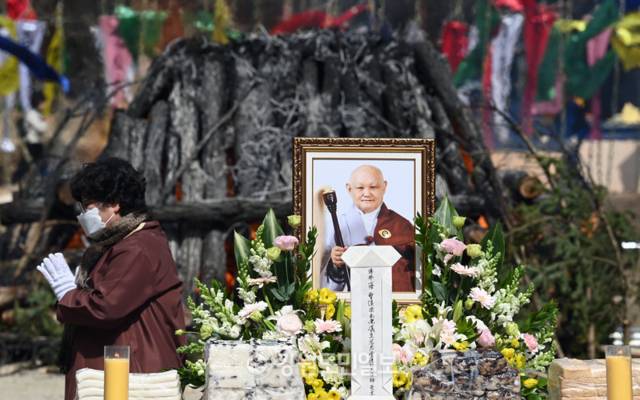 ▲ 16일 평창 월정사에서 봉행된 선덕 자광당 원행 대종사 다비식에서 한 신도가 기도를 하며 붉게 타오르는 연화대를 돌고 있다. 방도겸 기자