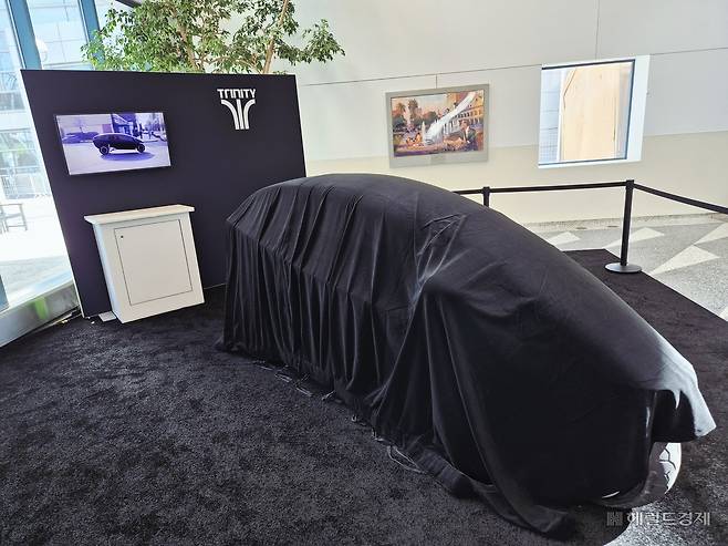 15일(현지시간) 찾은 미국 캘리포니아주 새너제이 맥에너리 컨벤션센터 입구에는 트리니티의 AI 삼륜 전기차가 베일에 가린 채 개막을 기다리고 있었다. 김현일 기자