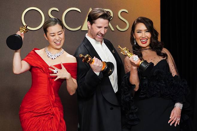 15일(현지시간) 제98회 아카데미 시상식에서 장편 애니메이션상과 주제가상을 수상한 ‘케이팝 데몬 헌터스’의 매기 강 감독(왼쪽부터)과 크리스 아펠한스 감독, 미셸 웡 제작자가 트로피를 들고 포즈를 취하고 있다. [AP]
