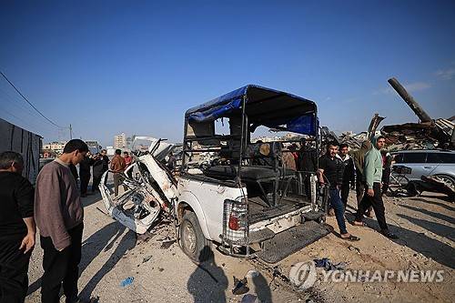 15일(현지시간) 가자지구에서 이스라엘의 공습을 받은 경찰차를 팔레스타인인들이 살펴보고 있다. [AFP=연합뉴스 제공]