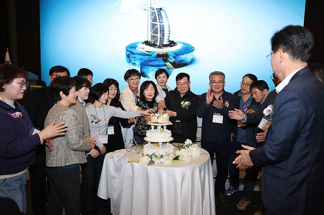 저동초 29회 졸업생들이 총동문향우회 현장에서 마련된 환갑 잔치에서 케이크를 자르며 환하게 웃고 있다. /총동문향우회 제공