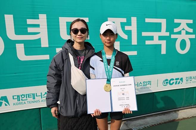 U-12 2관왕을 노리는 김예율이 여자복식 금메달 시상식 뒤 어머니와 포즈를 취하고 있다. 대한테니스협회