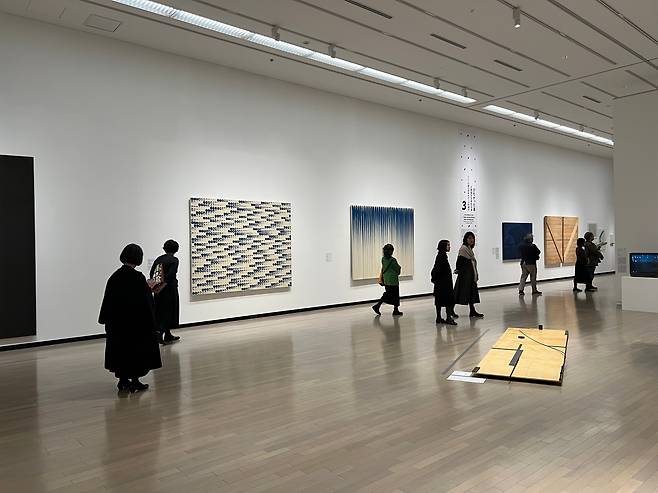 1970년대 한일 미술 교류를 소개한 3부 전시장 벽에 한국 작가 이우환의 ‘점으로부터’와 ‘선으로부터’, 일본 작가 사이토 요시시게의 ‘작품 4′와 ‘반대칭 대각선 No. 1, No. 2′(왼쪽부터)이 나란히 걸려 있다. 오른쪽 바닥에는 일본 작가 에비즈카 고이치의 설치 작품 ‘조응-1977년 7월 대구의 여운’이 놓였다. /국립현대미술관