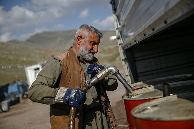 11일 이라크와 이란 국경 바쉬마그 인근에서 한 공급업체가 휘발유를 펌핑하고 있다. /연합뉴