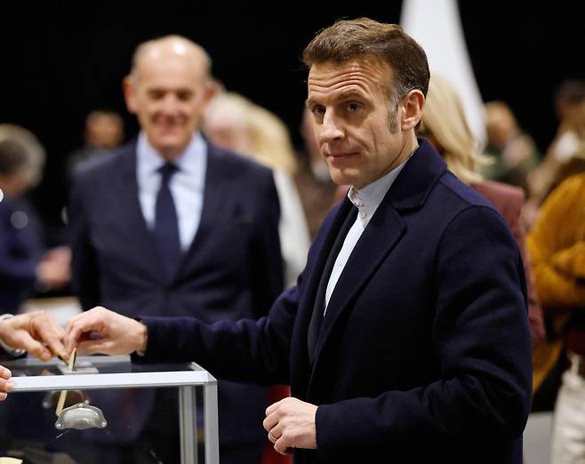 에마뉘엘 마크롱 프랑스 대통령(오른쪽)이 지방선거 1차 투표가 열린 15일 르투케파리플라주에서 표를 행사하고 있다. 르투케파리플라주=AP 뉴시스