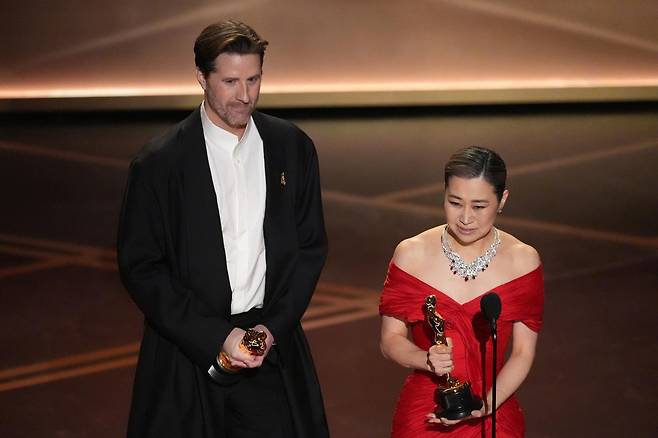 매기 강(오른쪽) 감독이 15일(현지 시간) 미 캘리포니아주 로스앤젤레스 돌비 극장에서 열린 제98회 아카데미 시상식에서 케이팝 데몬 헌터스(케데헌)로 장편 애니메이션상을 받은 후 소감을 말하고 있다. 왼쪽은 크리스 아펠한스 공동 연출자. 2026.03.16 로스앤젤레스=AP/뉴시스