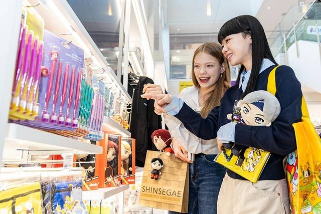 외국인 관광객이 신세계면세점 ‘K-웨이브 존’의 BTS 굿즈를 구경하고 있다. [신세계면세점 제공]