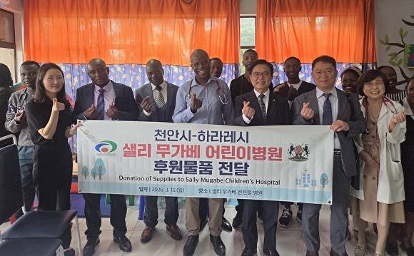 김석필 천안시장 권한대행(오른쪽 세 번째)이 짐바브웨 하라레시청에서 제이콥 마퓸 하라레시장에게 우호교류 10주년 기념패를 전달하고 기념촬영을 하고 있다 [사진=천안시]