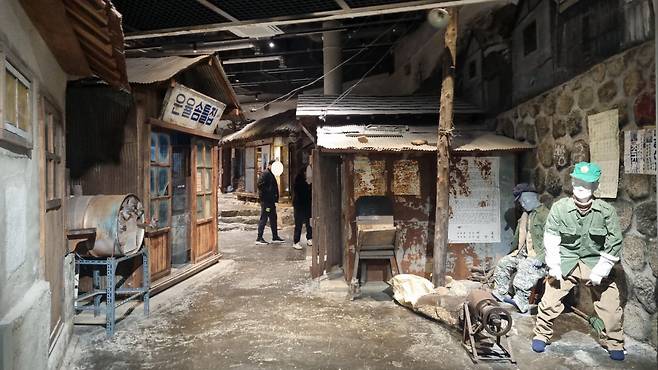 수도국산 박물관 지하 1층에 마련된 상설전시관에서 관람객들이 1971년 수도국산 달동네를 재현한 골목길 풍경을 살펴보고 있다.  수도국산 달동네 박물관·박준철 기자