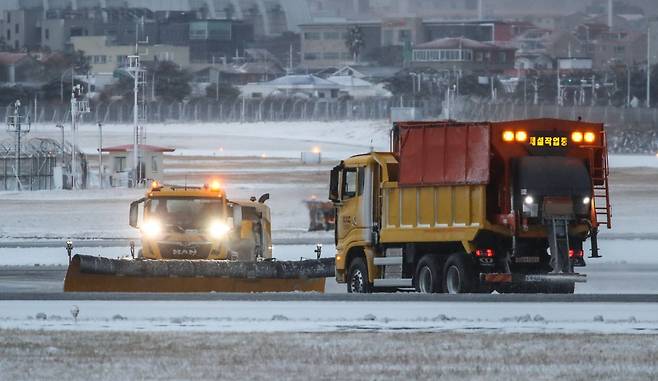 제주 지역 강설로 제주공항 활주로가 전면 폐쇄된 8일 오전 제주국제공항에서 제설작업이 이뤄지고 있다. 뉴시스