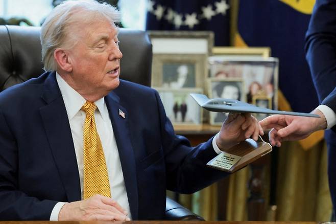 도널드 트럼프 미국 대통령이 16일(현지시간) 워싱턴 백악관 집무실에서 B-2 폭격기 모형을 건네받고 있다. 로이터 연합뉴스